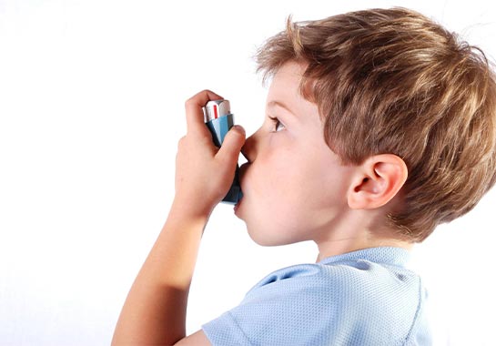 Menino de 7 anos usando spray para asma - Clínica do Pulmão